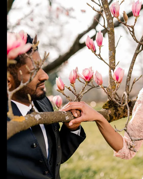 Paar zwischen hellen Magnolienblüten